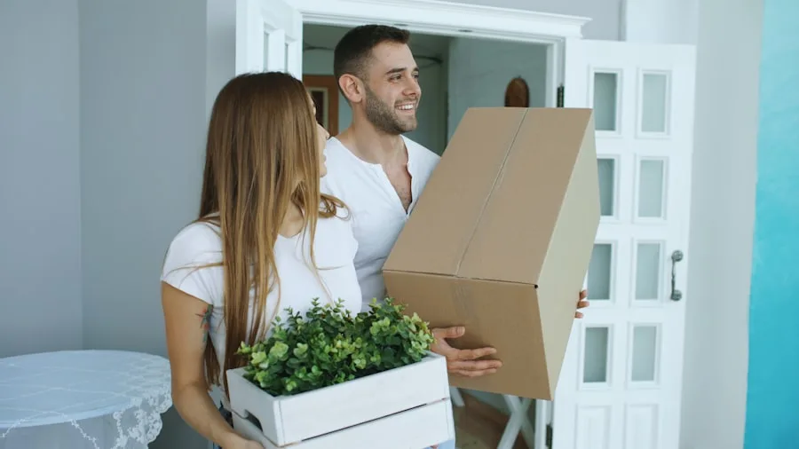 Couple carrying boxes into their new apartment on moving day